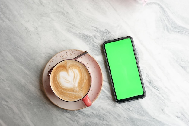 Cpu di caffè e telefono mart con schermo verde sul tavolo