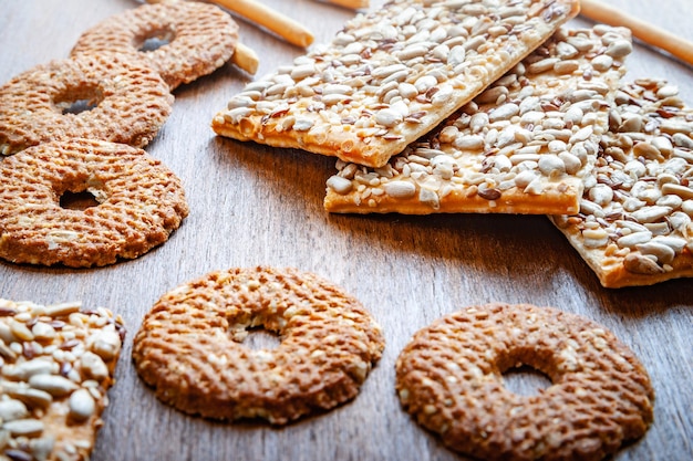 Cracker croccanti di biscotti con semi di girasole di lino e sesamo su fondo di legno