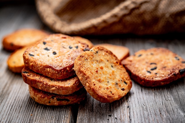 Cracker croccanti salati con sesamo e semi di girasole sul vecchio tavolo da cucina. Cibo salutare