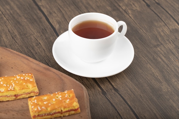 Cracker dolci con semi e una tazza bianca di tè caldo.