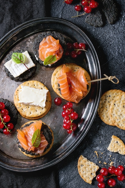 Cracker neri con salmone e frutti di bosco