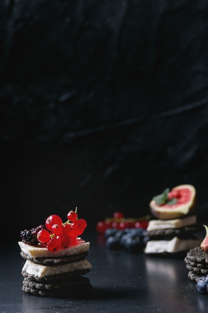 Cracker nero con formaggio e frutti di bosco