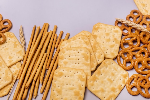 Cracker salati bastoncini salatini sopra sfondo blu Snack per feste Mix varietà di gustosi cracker