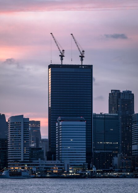 Cranes in città contro il cielo durante il tramonto
