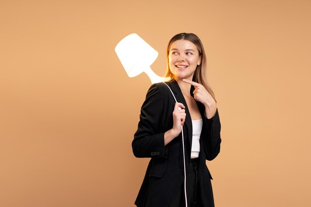 Creatività e innovazione sono le chiavi del successo Concetto di nuova idea e innovazione con lampada leggera Bella donna caucasica sorridente che tiene la lampada in mano e sorriso isolato