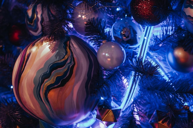 Creativo albero di Natale blu decorato con pallina di Natale dipinta a mano e ghirlanda di luci al neon