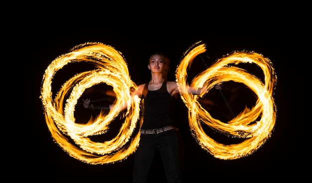 Creazione di incredibili modelli di fuoco Donna sexy rotola il personale del drago nell'oscurità Manipolazione del personale del fuoco a rotazione Stile di manipolazione Spettacolo notturno Festa del partito Celebrazione delle vacanze