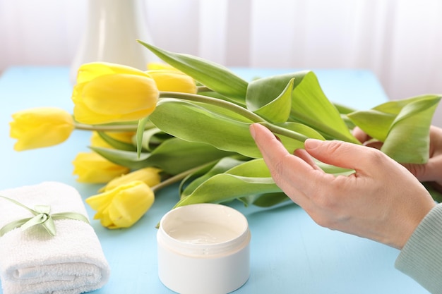 Crema cosmetica e tulipani gialli sul tavolo