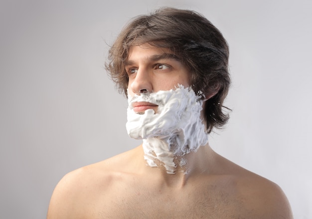 Crema da barba sul viso di un uomo