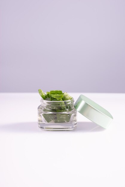 Crema di aloe in contenitore di vetro su fondo bianco Estratto di aloe per cosmetici naturali e medicina alternativa