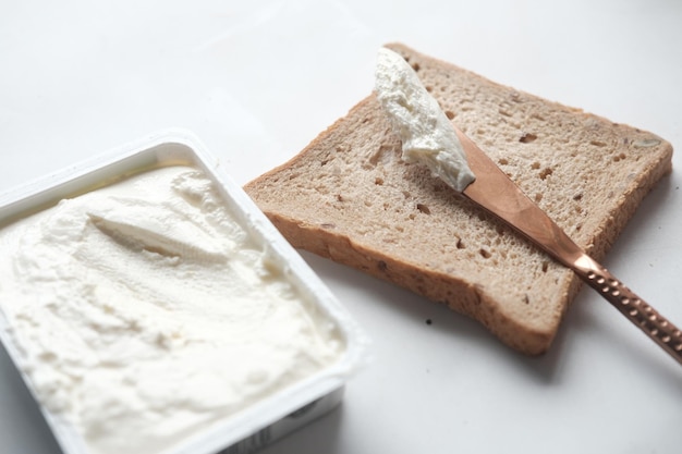 Crema di formaggio a basso contenuto di grassi spalmata su un pane