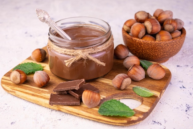 Crema spalmabile al cioccolato con nocciole su tavola di bambù