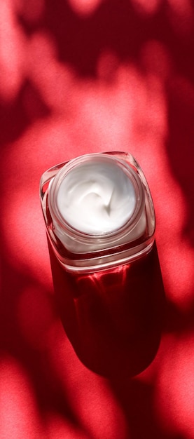 Crema viso idratante di bellezza per pelli sensibili cosmetici spa di lusso e prodotti per la cura della pelle naturali e puliti su sfondo rosso