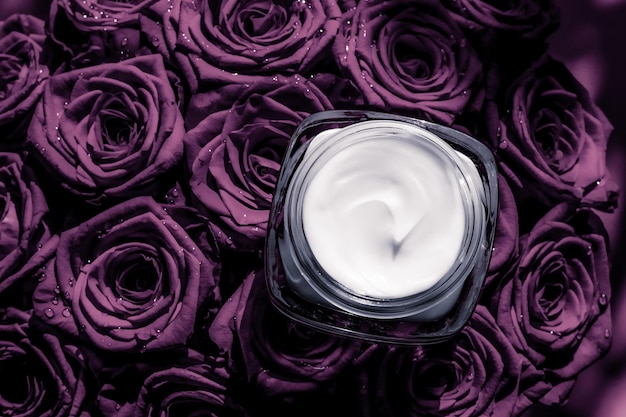 Crema viso idratante per la pelle su rose viola fiori di lusso per la cura della pelle prodotto cosmetico su sfondo floreale come design flatlay per le vacanze di marca di bellezza