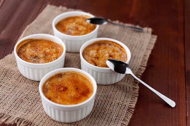 Creme brulee in una ciotola bianca con crosta di zucchero. Fotografia in studio. stile country.