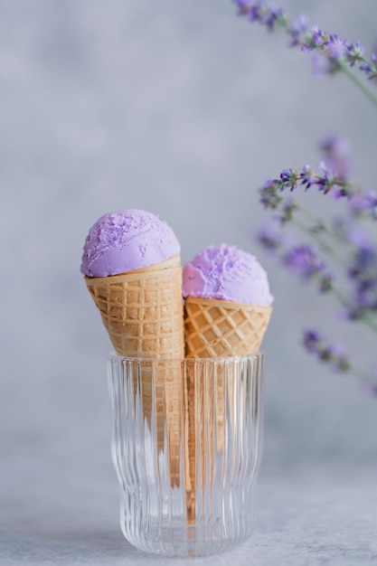 Cremoso gelato vegano alla lavanda nel corno in bicchiere con fiori di lavanda