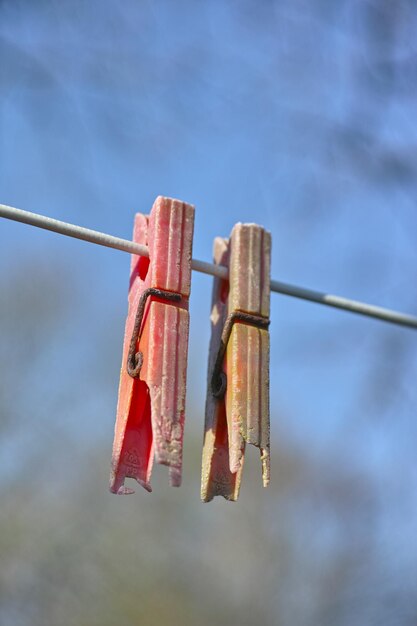 Crepa di decadimento del materiale plastico e scolorimento sugli oggetti domestici causati dalle radiazioni UV Dettagli del primo piano di vecchi pioli su una linea di abbigliamento all'aperto su sfondo sfocato con spazio per la copia