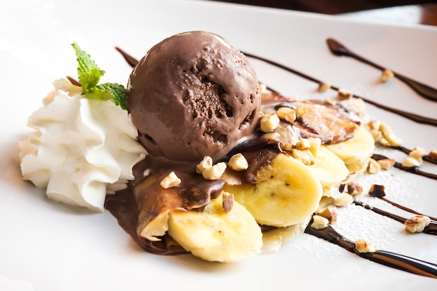 Crepe con gelato alla banana e al cioccolato. Dessert francese Servito su piatto bianco con whipp