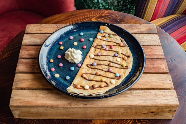 Crepe dolce con crema al cioccolato su fondo di legno