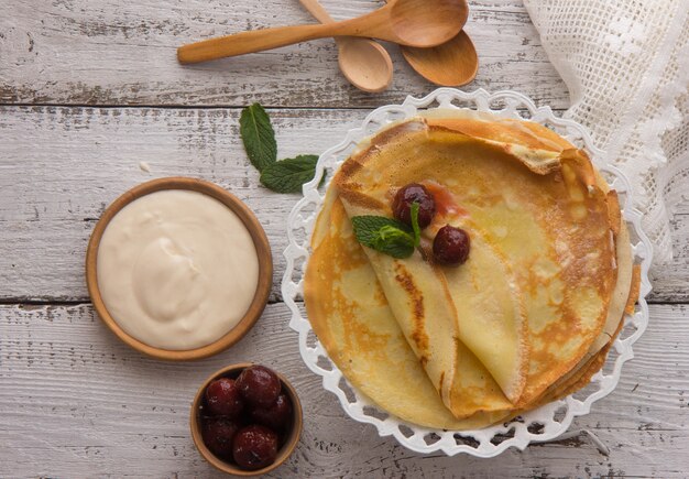 Crepes (Blini) e miele su fondo di legno, vista dall'alto, copia spazio. Crepes sottili fatte in casa per colazione o dessert.