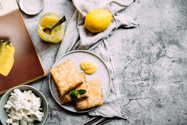 Crepes con ricotta fatta in casa e cagliata di limone su un piatto grigio