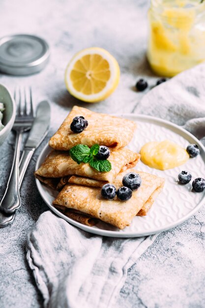 Crepes con ricotta fatta in casa e cagliata di limone su un piatto grigio