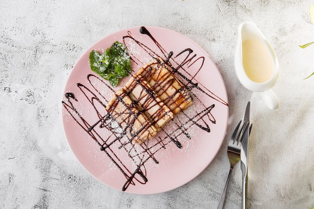 Crepes con salsa di cioccolato isolato su sfondo di marmo bianco. Cibo fatto in casa. Gustosa colazione Messa a fuoco selettiva. Foto di Hotizontal.