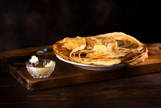 Crepes frittelle russe con burro su fondo di legno rustico