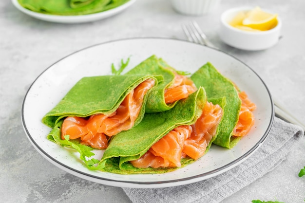 Crepes o frittelle di spinaci verdi con salmone affumicato e formaggio a pasta molle Copia spazio