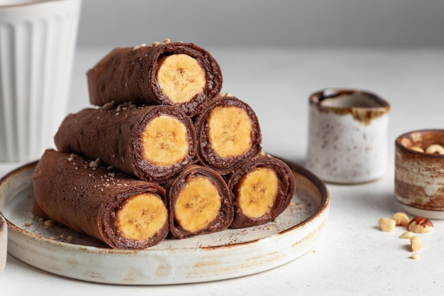 Crepes vegane al cioccolato arrotolate con ripieno di banana