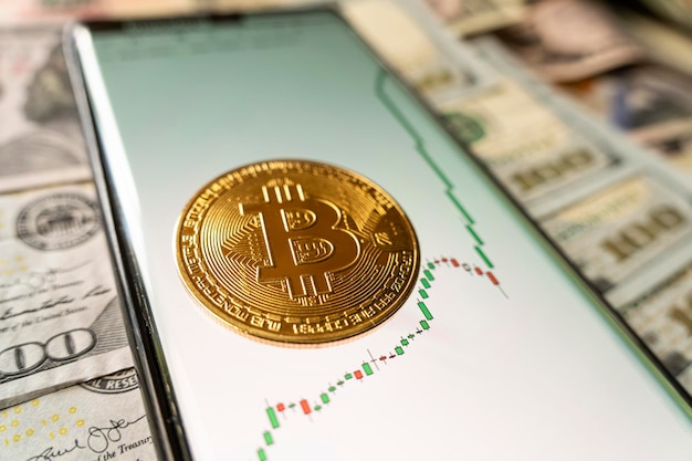 Crescita del tasso di cambio bitcoin sul grafico dello smartphone e sulla moneta d'oro bitcoin