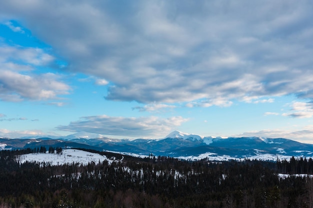 Cresta della montagna di giorno nuvoloso di inverno di sera