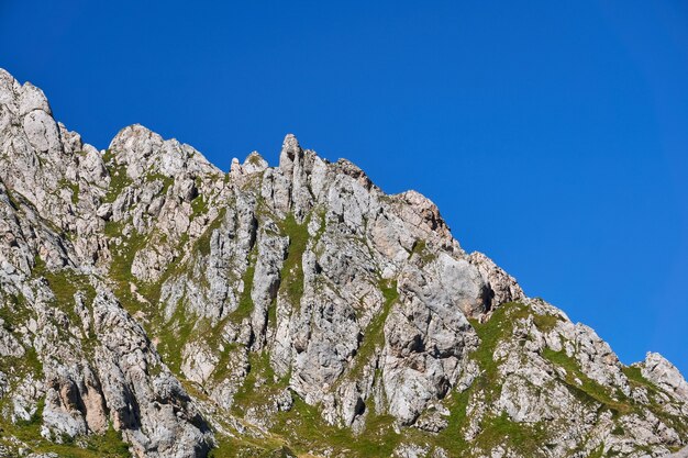 Cresta rocciosa scenica del calcare con vegetazione verde contro un cielo blu