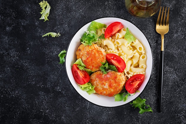 Creste di pasta e polpette di pollo al sugo di pomodoro. Vista dall'alto, sopra, copia spazio