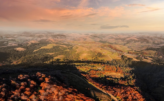 Crinale della montagna con la foresta sotto il cielo nuvoloso al tramonto