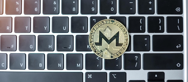 Criptovaluta d'oro su tastiera portatile Moneta Monero Crypto è denaro digitale all'interno della rete blockchain