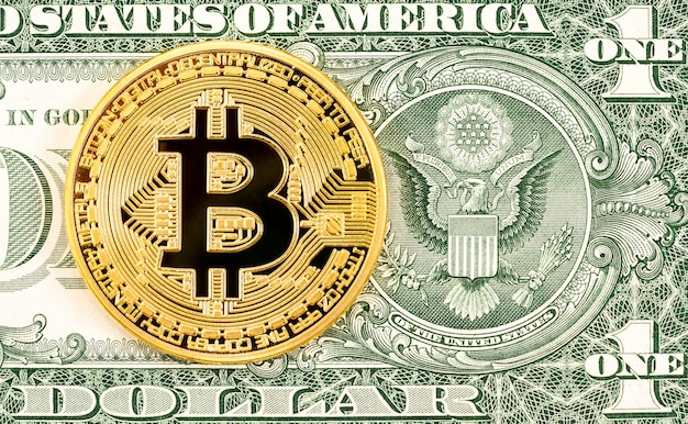 Criptovaluta Gold Bitcoin che giace sulla banconota da un dollaro