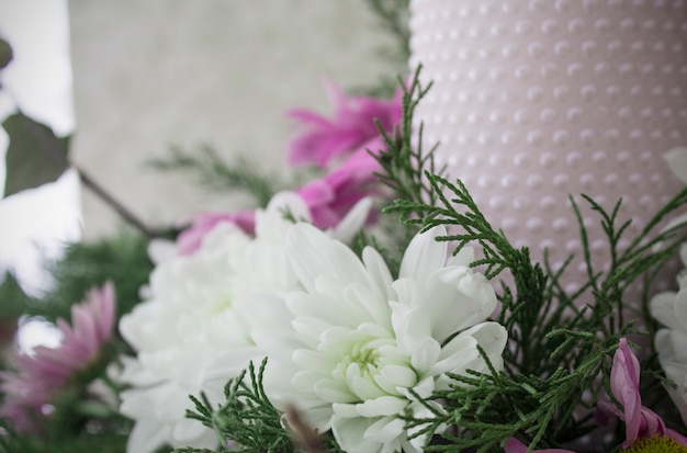 Crisantemi bianchi e rosa con rami ivy e ginepro. Fiorista fiorente.Chrysanthemums e candela