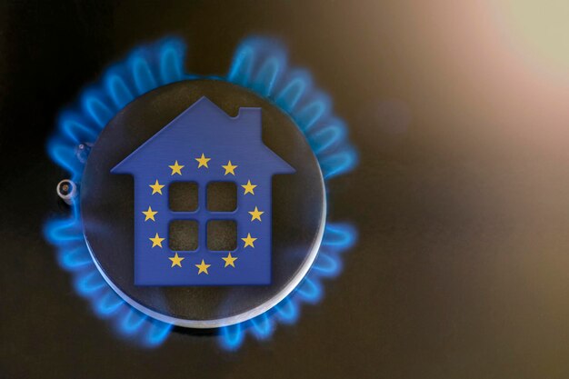 Crisi del gas Aumento dei costi delle utenze nell'Unione Europea Crisi energetica Problemi di esportazione e importazione in Europa Il concetto di bruciatore a gas e modello di casa sono colorati con i colori della bandiera