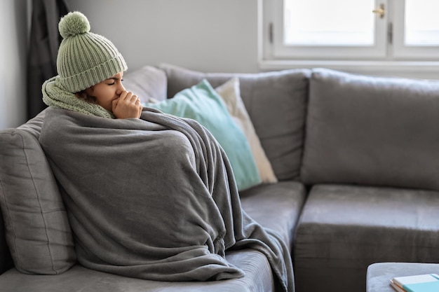 Crisi energetica Ritratto di donna coperta da una calda coperta seduta sul divano