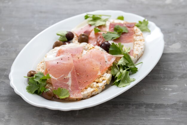 Crispy rice diet toast con prosciutto su superficie in ceramica