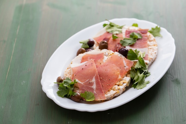 Crispy rice diet toast con prosciutto su superficie in ceramica