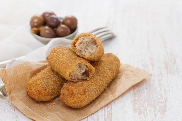 Crocchette di carne su carta su fondo in legno