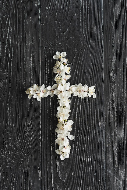 Croce che simboleggia la morte e la risurrezione di Gesù Cristo fiori primaverili su uno sfondo di legno