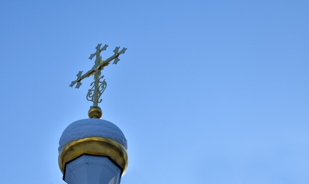 croce d'oro della chiesa contro il cielo