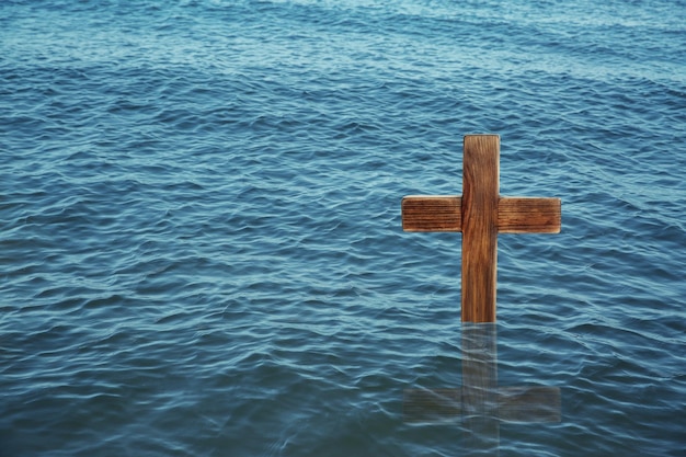 Croce di legno nel fiume per rituale religioso noto come battesimo