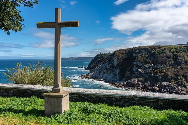 Croce di pietra di fronte alle scogliere del Mar Cantabrico nella località turistica di Luarca Asturias