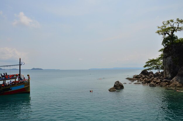 Crociera in nave o tour in barca sosta per inviare ricevere thailandesi e viaggiatori stranieri viaggio visita riposo relax e gioco nuoto nell'oceano mare nel Golfo di Thailandia all'isola di Koh Chang a Trat Thailandia