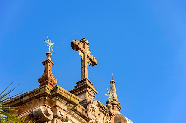 Crocifisso e ornamenti sulla facciata di una vecchia chiesa barocca nella città di Ouro Preto nel Minas Gerais