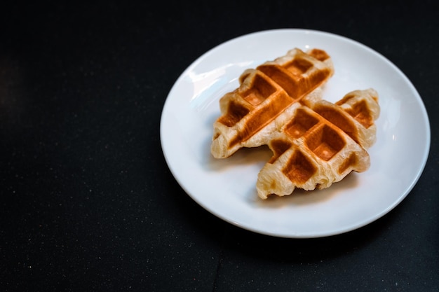 Croffle è una combinazione di croissant e waffle Questo croffle servito su un piatto bianco